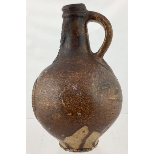 121 - BELLARMINE JUG. 8.25ins. Dipped brown body
glaze with some runs. Bulbous bodied, bearded face cartou... 