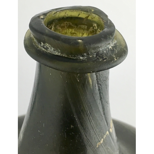 597 - ENGLISH ONION WINE BOTTLE. 5.1ins tall, deep dark black/ green glass, c. 1700-1710, thin string lip ... 