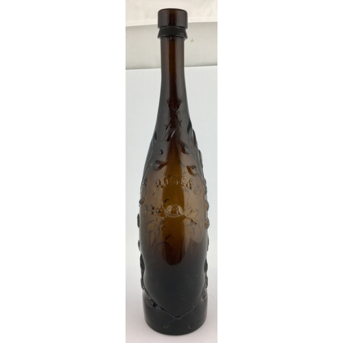 609 - ROSES LIME JUICE BOTTLE. 12ins tall, elegant long necked champagne shape, black/ dark brown glass. H... 