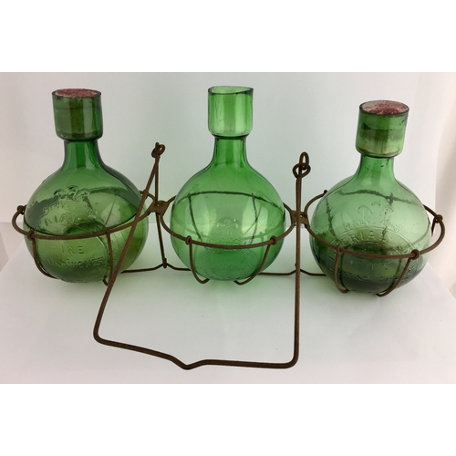 613 - IMPERIAL FIRE GRENADES IN RACK. Trio of bright green glass spherical bodied grenades, each 6.5ins ta... 