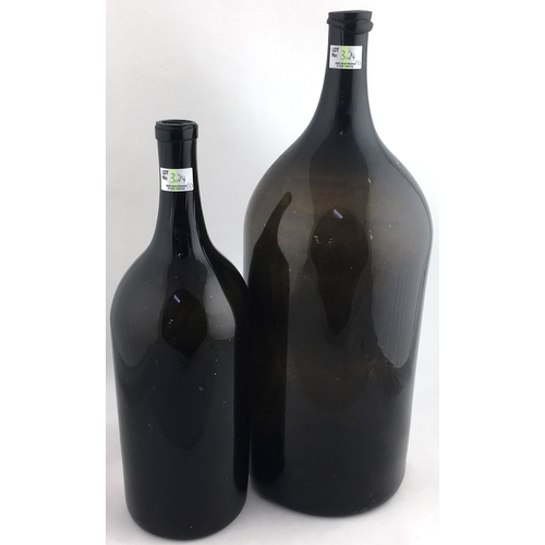 324 - BLACK GLASS WINE DUO. Tallest 19ins, one has longer neck & pontilled, larger one has body crack. (2)