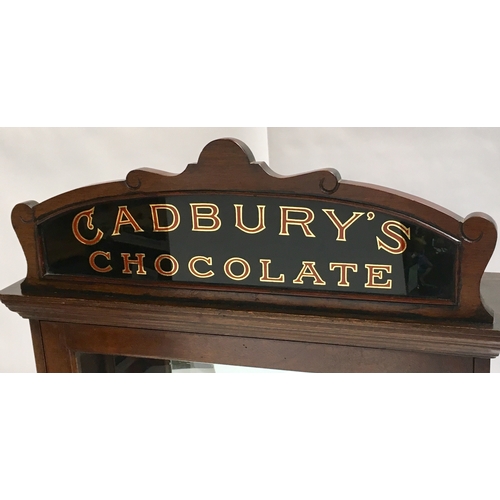 53 - CADBURY’S CHOCOLATE FRONT LOADING CABINET. 20.75 by 43ins tall. Origianl top finial & etched glass f... 