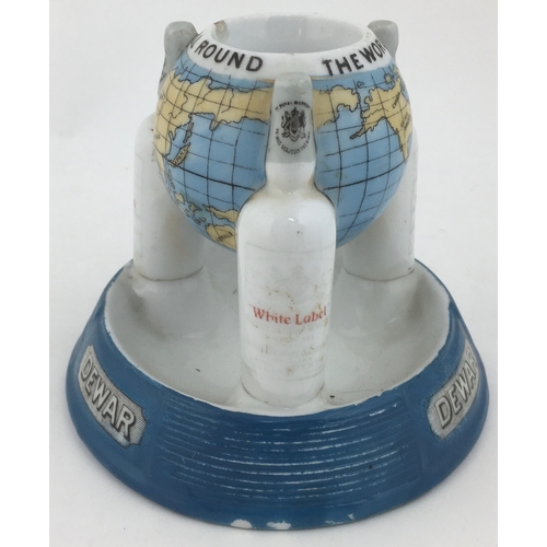 112 - DEWARS GLOBE MATCHSTRIKER. 4.4ins tall. World globe held aloft by 3 ‘White Label’ bottles set on a w... 