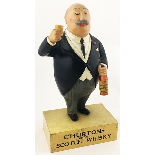 118 - CHURTONS SCOTCH WHISKY ADVERTISING FIGURE. 10.25ins tall, rubberoid portly gent bottle & glass in ha... 