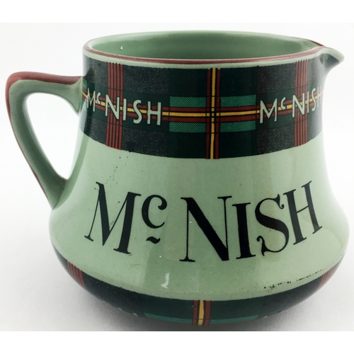 112 - MCNISH WHISKY JUG. 4ins tall. Squat shape, rear handle, pale green glaze with tartan detail top & bo... 