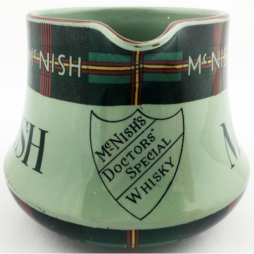 112 - MCNISH WHISKY JUG. 4ins tall. Squat shape, rear handle, pale green glaze with tartan detail top & bo... 