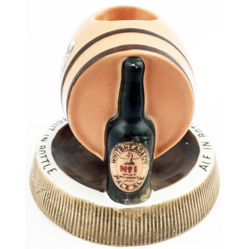 186 - HITBREADS BOTTLED BEERS MATCHSTRIKER ASHTRAY. 5ins diam. Side laying peach coloured barrel, supporti... 