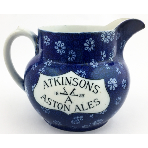 214 - 4.2ins tall. Dark blue floral body printed jug, white plaques carrying the black letters Atkinsons A... 