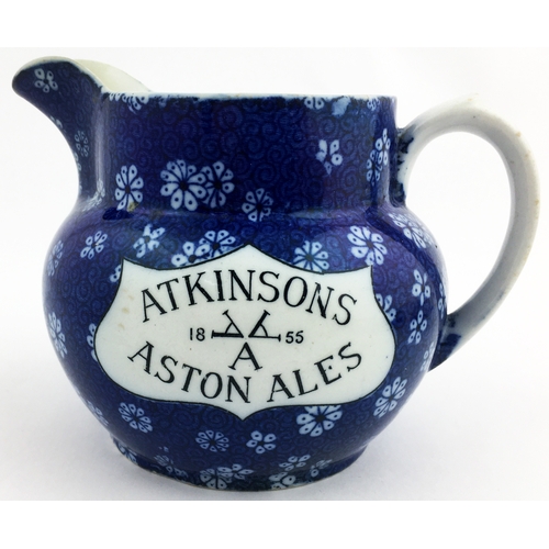 214 - 4.2ins tall. Dark blue floral body printed jug, white plaques carrying the black letters Atkinsons A... 