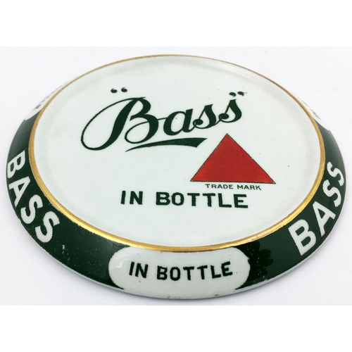 293 - BASS COASTER. 4.9ins diam. Raised dark green outer rim repeating 3 times BASS/ IN BOTTLE. Centre car... 