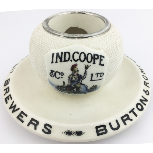 39 - IND COOPE & CO MATCHSTRIKER/ ASHTRAY.  6ins diam. Multi-coloured pictorial t.m. on sprig like shield... 