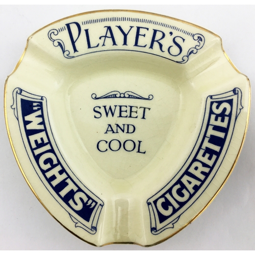 75 - PLAYERS WEIGHTS CIGARETTES ASHTRAY. 4 ins triangular blue print gold rimmed ashtray. Blue base trans... 