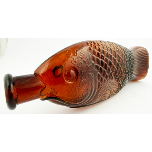 41 - DOCTOR FISCH'S BITTERS BOTTLE. 11.5ins tall. Dark amber glass, moulded in the shape of a fish, gre... 