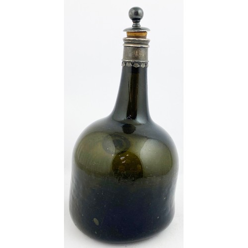 56 - FAT BODIED CYLINDER WINE BOTTLE. 10ins to top of stopper. Dark olive green glass. Seal features a de... 