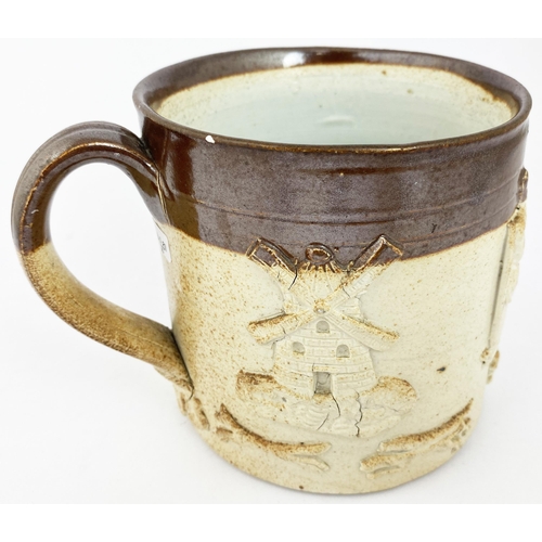 64 - HANDLED MUG. 5.1ins tall, t.t, very dark rim. vine style base of handle sprig, rest of body adorned ... 