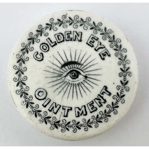 677 - GOLDEN EYE OINTMENT LID. 1.75ins diam. Black transfer with eye pict to centre. Edge & under edge wea... 