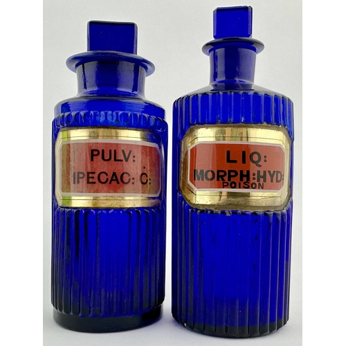 198 - PHARMACY LABEL UNDER GLASS SHOP ROUND DUO. Tallest 6.8ins. Cobalt blue glass, both vertically ribbed... 