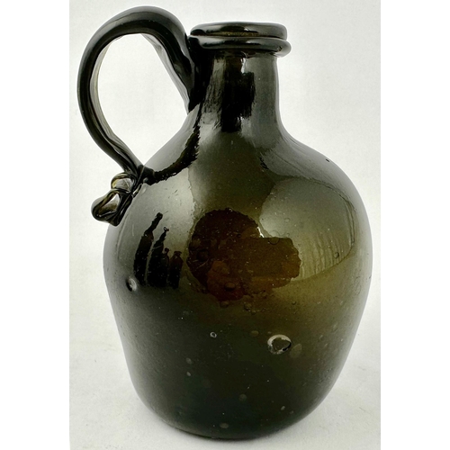 236 - ENGLISH FREEBLOWN HANDLED FLAGON BOTTLE. 4.8ins tall. Dense black/ dark green glass, globular form, ... 