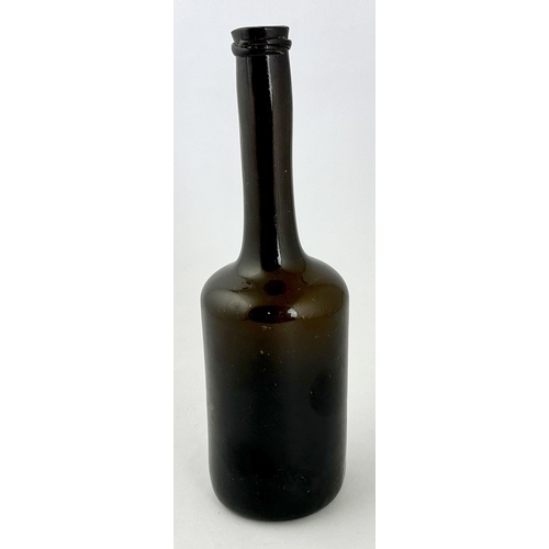 242 - LADIES LEG BLACK GLASS WINE BOTTLE. 11.1ins tall. Heavy, crude cylinder form, dense black glass, fea... 