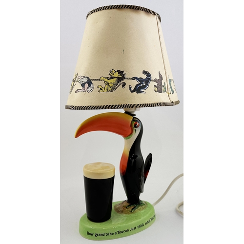 210 - GUINNESS TOUCAN LAMP BASE & SHADE. 17ins tall. 210. Multi colopured toucan on green, lettered, base,... 