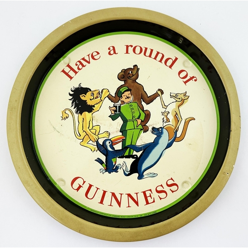 218 - GUINNESS TIN TRAY. 10.6ins diam. Zookeeper dancing with animals. Very minor marks, overall very good... 