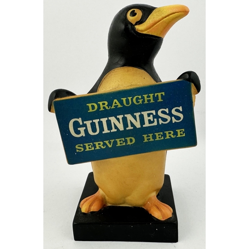 223 - GUINNESS PENGUIN FIGURE. 7ins tall. Naturalistically coloured hollow rubberoid penguin holding plack... 