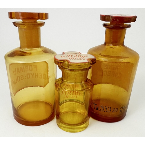 56 - LABELLED PHARMACY SHOP ROUNDS. Tallest 5.8ins tall. Golden amber, each with cross shaped stoppers. L... 