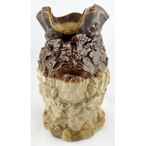 531 - SPRIGGED SALT GLAZE JUG. 9ins tall. Very heavily modelled with leaves, crown, militaria, acorns & al... 