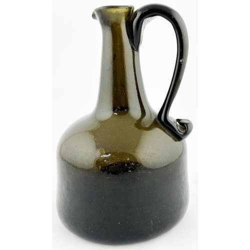 632 - ENGLISH HANDLED MALLET WINE BOTTLE. 8ins tall, black/ dark green glass. Delightful hand applied scro... 