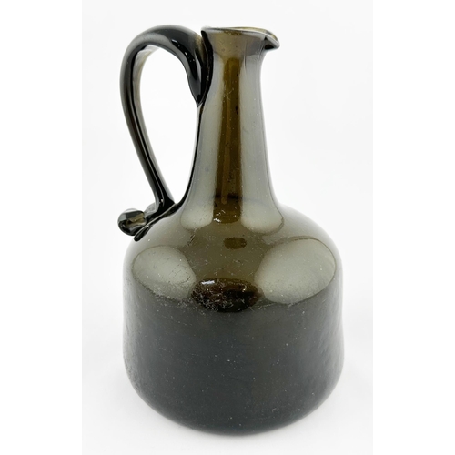 632 - ENGLISH HANDLED MALLET WINE BOTTLE. 8ins tall, black/ dark green glass. Delightful hand applied scro... 