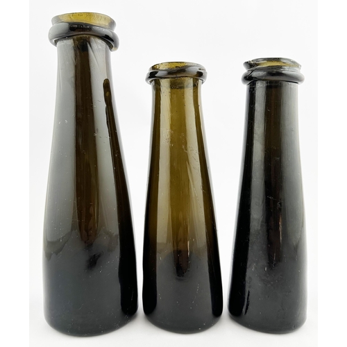 634 - TRUFFLE BOTTLE TRIO. Tallest 9.8ins. A very fine group of wonderfully crude black/ dark brown wide m... 