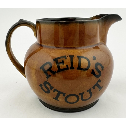 27 - REIDS STOUT WATER JUG. 4.8ins tall, pouring lip, rear handle. Varied brown shiny body glaze. Transfe... 
