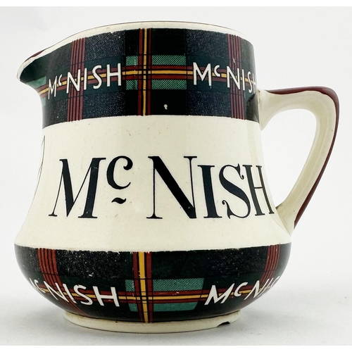 91 - MCNISH WHISKY JUG. 4ins tall. Tartan design to neck & base. Red rim and handle. Special Scotch shiel... 