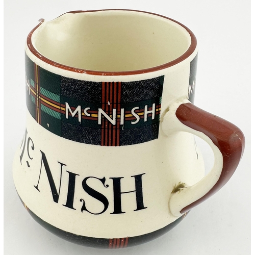 91 - MCNISH WHISKY JUG. 4ins tall. Tartan design to neck & base. Red rim and handle. Special Scotch shiel... 