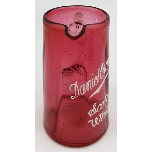 94 - DANIEL CRAWFORDS SCOTCH WHISKY WATER JUG. 5.3ins tall. Very small (cute?) cranberry tapering jug, wh... 