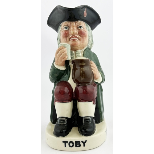 121 - TOBY ALE & STOUT TOBY JUG 9.1ins tall. Familiar multi-coloured seated red cheeked toper, glass in ha... 