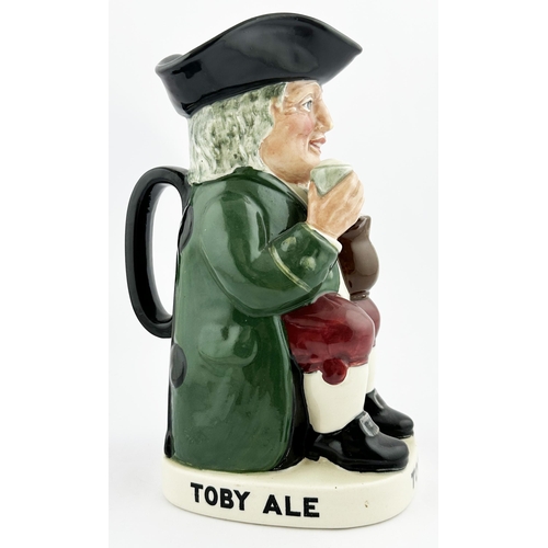 121 - TOBY ALE & STOUT TOBY JUG 9.1ins tall. Familiar multi-coloured seated red cheeked toper, glass in ha... 