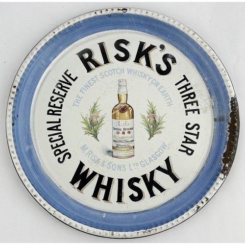 222 - RISKS WHISKY ENAMEL TRAY. 12ins diam. Thistle pict to centre with whisky bottle. Rear p.m. Minor res... 