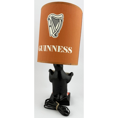 243 - 14.3ins to shade top. Coloured Carltonware penguin base holding promotional banner. Named shade (top... 