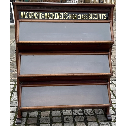 286 - MACKENZIE & MACKENZIES HIGH CLASS BISCUITS CABINET. 49.7ins tall, 42ins wide, 16.5ins deep. Three ti... 