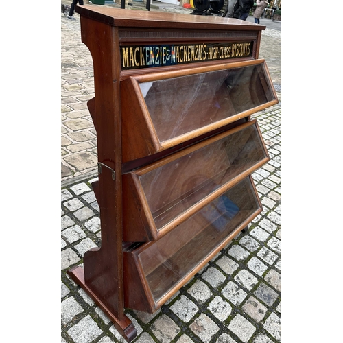 286 - MACKENZIE & MACKENZIES HIGH CLASS BISCUITS CABINET. 49.7ins tall, 42ins wide, 16.5ins deep. Three ti... 