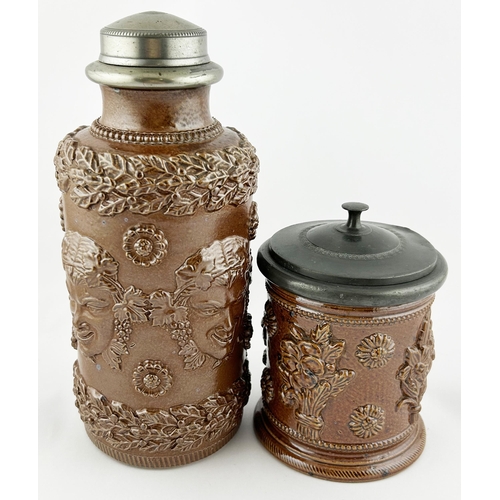 88 - SALT GLAZE TOBACCO JAR DUO. Tallest 9.5ins. One floral design other with added faces. Sligh nicks to... 