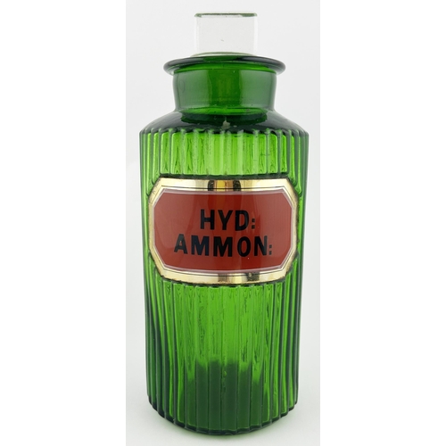 159 - CHEMIST ROUND. 9.75ins tall. Green ribbed, label under glass with stopper. Slight damage to lid & la... 