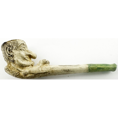 448 - MINIATURE PUNCH PIPE. 2.7ins long. Detailed Mr Punch like head as pipe bowl, green mouthpiece. Some ... 