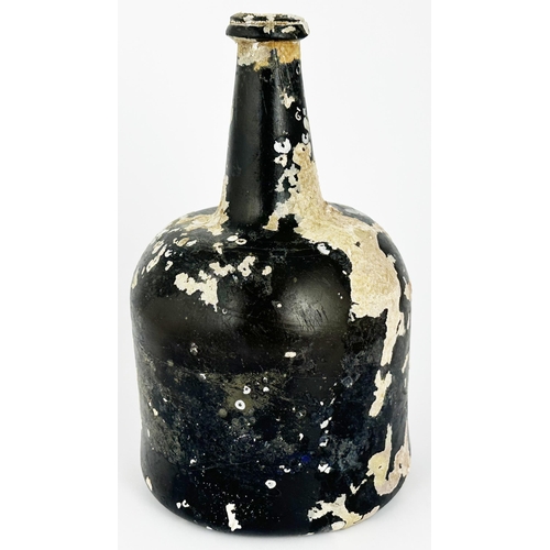 461 - ENGLISH MALLET WINE BOTTLE. 8ins tall. Black glass, dull. Perhaps the most barnacled and characterfu... 