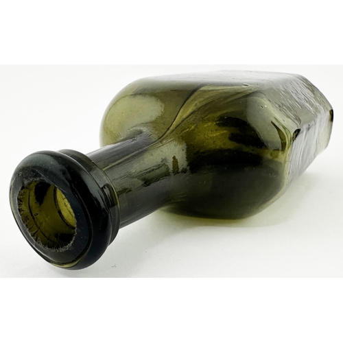 565 - ENGLISH FREEBLOWN UTILITY BOTTLE. 5 ins tall. Very dark green/ black glass. Rectangular base, facett... 