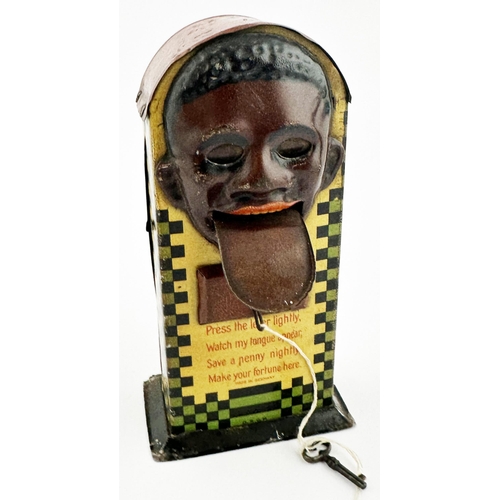 82 - BLACK PERSON HEAD TINPLATE MONEY BOX. 7.1ins tall. Multi coloured lithographed curved top money box,... 