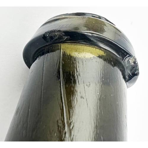 161 - . ENGLISH BLADDER WINE BOTTLE. 8.1ins tall. Black, very dark green, glass, flat ovoid base shape wit... 