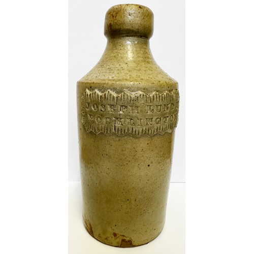 434 - POCKLINGTON SLAB SEALED GINGER BEER BOTTLE. 6.5ins tall. Green grey slip glaze. Pie crust front seal... 