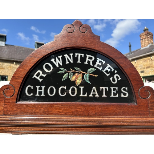 112 - ROWNTREES CHOCOLATES CABINET WITH PEDIMENT. 40.5 x 32.25 x 17.25ins. Dark Wood, two internal glass s... 